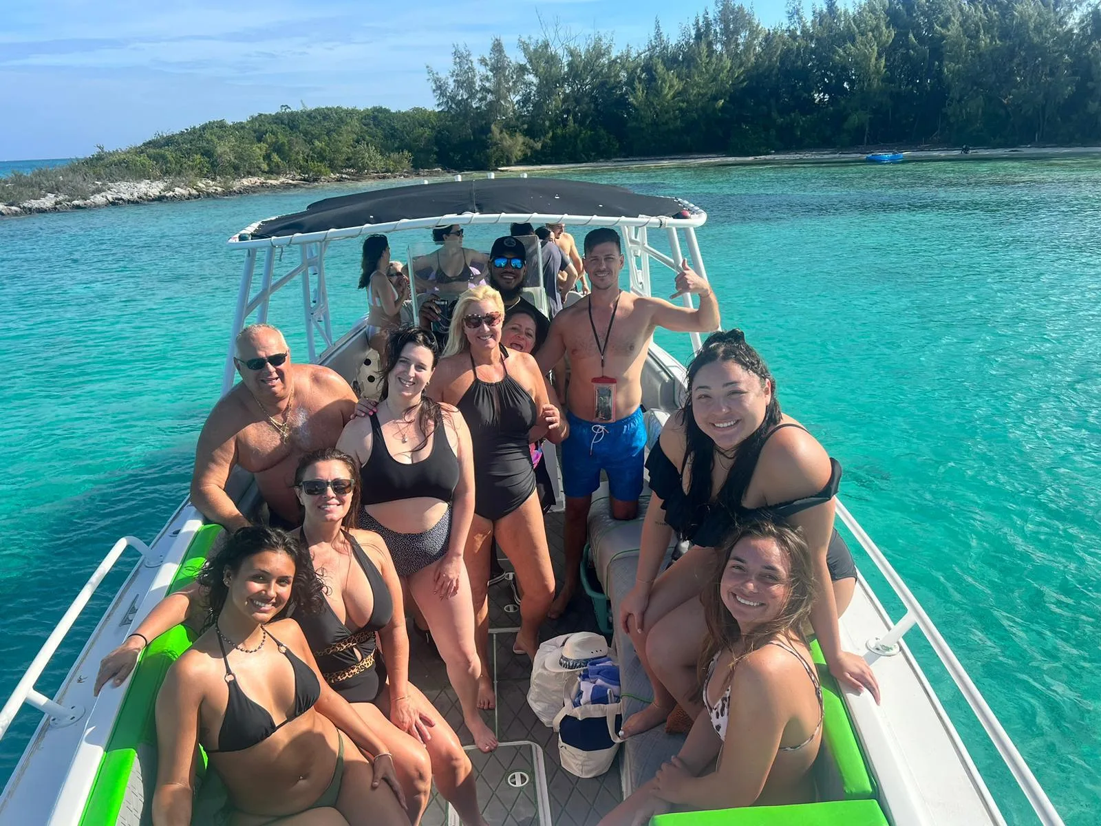 The tour group seated under the canopy of the speedboat between island stops